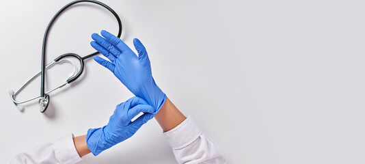 Top view of an unrecognizable female doctor putting on gloves