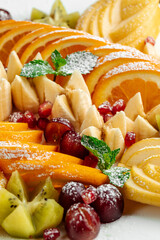 Closeup on assorted fruit plate set appetizer with powdered sugar