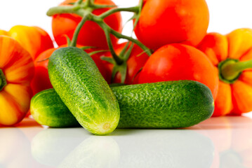 Ripe eco vegetables isolated on white. Tomato, sweet paprika and cucumbers close-up.