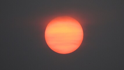 The orange sun in the smoke of forest fires in Yakutia can be viewed with an unarmed eye
