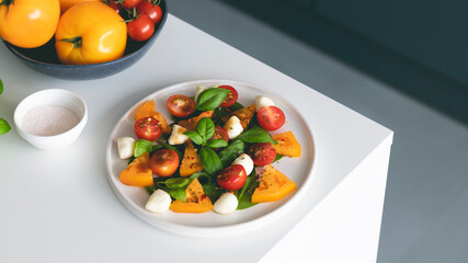Italian caprese salad with tomatoes, mozzarella cheese and basil in plate