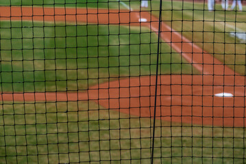 Baseball field with focus on protective net in foreground