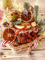 Christmas food gift basket,  Food Christmas gift made of cookies, honey, homemade handmade sweets, dried oranges, lollipops on a wooden table.Concept handmade christmas gifts, Handmade food presents