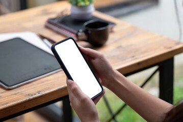 Mockup a woman hand holding a smartphone blank white screen at the office.