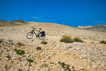 a lonely bicycle in front of a barren landscape in croatia on island pag.