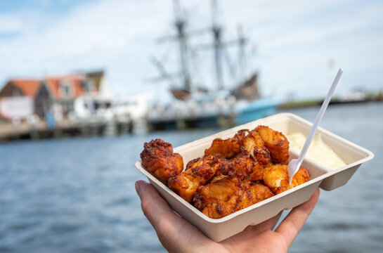 Portion of popular dutch street snack food called kibbeling, which consists of fried cod fish and a sauce