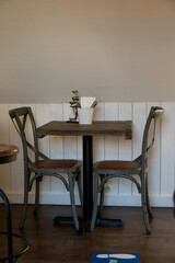 Empty rustic restaurant table with two chairs and simple decor