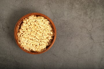 Ready-to-eat instant noodles in a brown wooden cup.