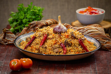 Delicious Fergana pilaf. Uzbek favorite dish on wooden background