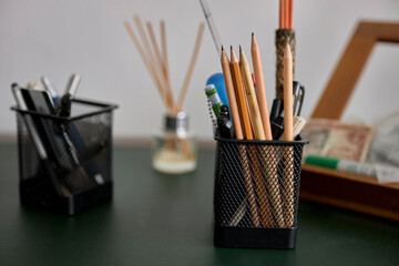 A basket of pencils and pens on an office table