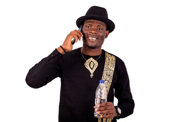 Fototapeta premium young man talking on mobile phone and holding bottle of mineral water.