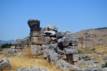 Fototapeta na wymiar Ruins of ancient column and construction blocks of antique city Hierapolis, in Pamukkale, Turkey