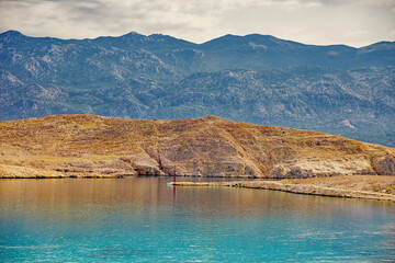 the harbour entry of pag with mountains in background