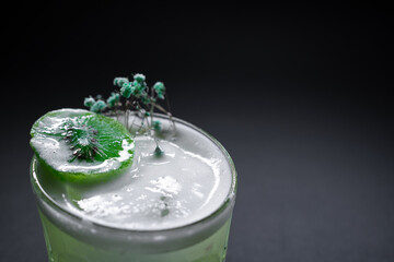 fresh green kiwi kick alcohol cocktail drink in wineglass on black background