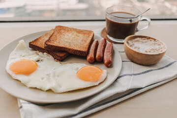 Fototapeta premium Easy breakfast set of fried eggs toasted bread sausages and tuna spread.