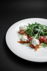 closeup of salad with salted salmon, cream cheese or arugula on black background