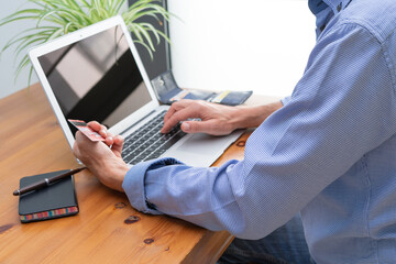 Man in front of computer paying online.