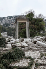 Naklejka premium Arch of Temple of Hadrian in ancient abandoned city Termessos in Turkey mountains