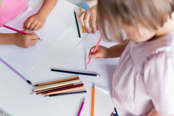 high angle view of kids drawing near kindergarten teacher