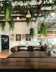 Empty wooden table top with lights bokeh on blur restaurant background.