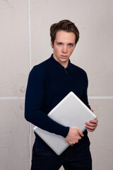 Strict businessman with a laptop in his hands. Work online. The man on a white background.