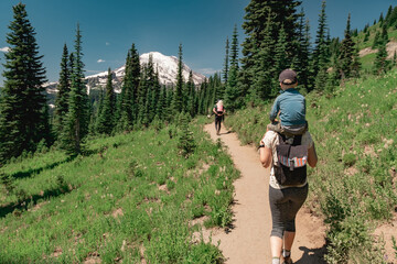Young family hiking toward Mt Rainier on the Naches Peak Loop Trail in Mt. Rainier National Park