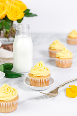 Vanilla cupcakes with yellow frosting on a white background