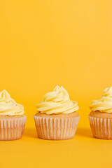 Vanilla cupcakes with yellow frosting on a bright yellow background