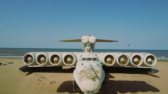 Old plane on beach. Action. Military plane landed on coast of sea many years ago. Abandoned military plane on seashore with history