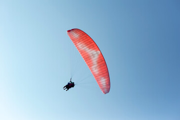 Couple of people paragliding against blue sky. Paragliding as Parachuting Tourist sport. Sky freedom Concept