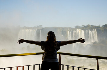 person standing on a bridge in the iguazu waterfalls - Powered by Adobe