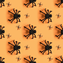 Seamless pattern of black different spiders on orange background. Halloween party pattern.