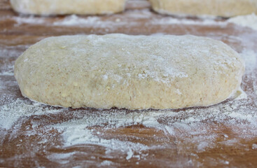 Yeast puff pastry. Photo from above. Photo of dough on a wooden board with flour. Whole grain flour dough.