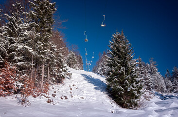Winter Berglandschaft mit Skilift in verschneiten Wald Erholung Skigebiet in Bayern, Deutschland am sonnigen Tag