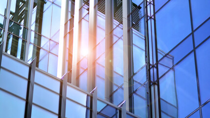 A beautiful background of an glass office building, reflecting blue sky in the windows.
