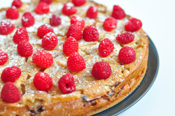 homemade raspberry-apple pie with powdered sugar. charlotte on white background