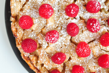 homemade raspberry-apple pie with powdered sugar. charlotte on white background