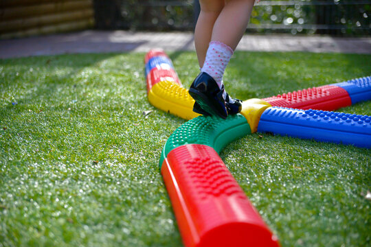 Child balancing on a balance beam in the garden.