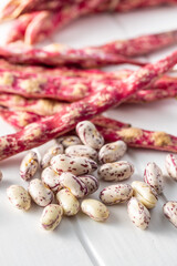 Cranberry beans. Beans pods on white table.
