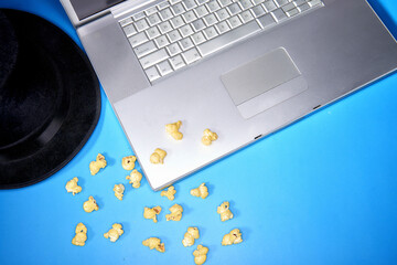 Photo of a laptop mac movie night shot from with hat and popcorn
