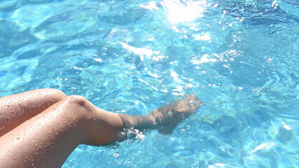 Female slender legs in turquoise water