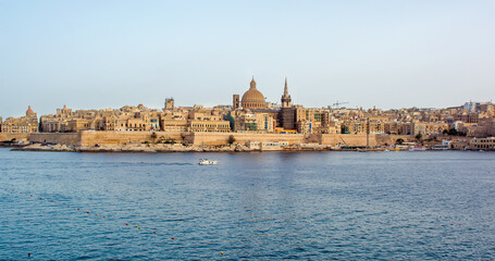 Fototapeta na wymiar Coastal landscape of Valletta at sunny summer day. Maltese Valletta skyline with church of Our Lady of Mount Carmel and St Paul's Pro-Cathedral.