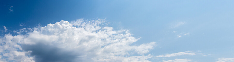 Naklejka na ściany i meble Big white cloud in the blue sky in sunny weather, panorama