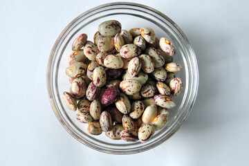 Colorful dragon tongue beans in a glass bowl,  white background