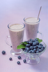 Fresh blueberry smoothie with milk in glasses