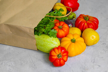 fresh organic vegetables in a paper bag on a concrete background