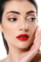 close up of young woman with red lips touching face isolated on white
