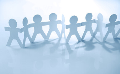 Paper chain team holding hands united in partnership. Teamwork concept idea