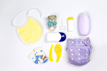 Set with baby hygiene products and bathroom items, shampoo, essential oil, baby soap, bib, socks, combs, reusable diaper and rattle. Accessories for baby hygiene. - obrazy, fototapety, plakaty