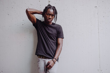 Portrait African man in black t-shirt standing near city wall